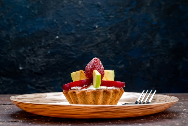 Una vista frontal poco delicioso pastel con crema dentro de la placa con fresas frescas en rodajas y manzanas sobre el fondo oscuro galleta bizcocho fruta