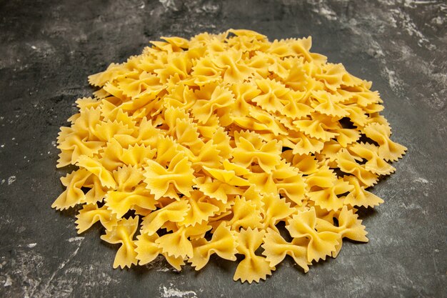 Vista frontal poco de pasta cruda en color gris oscuro foto de color de alimentos muchas pasta de pasta italiana