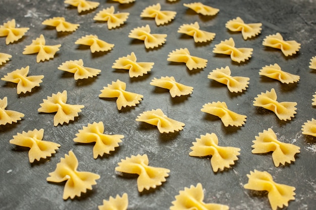 Vista frontal poco de pasta cruda forrada en color gris oscuro muchas fotografías en color de alimentos masa de comida pasta italiana