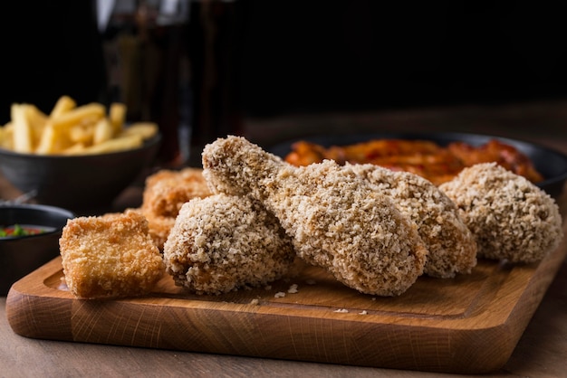 Vista frontal de pollo frito con papas fritas y bebida gaseosa