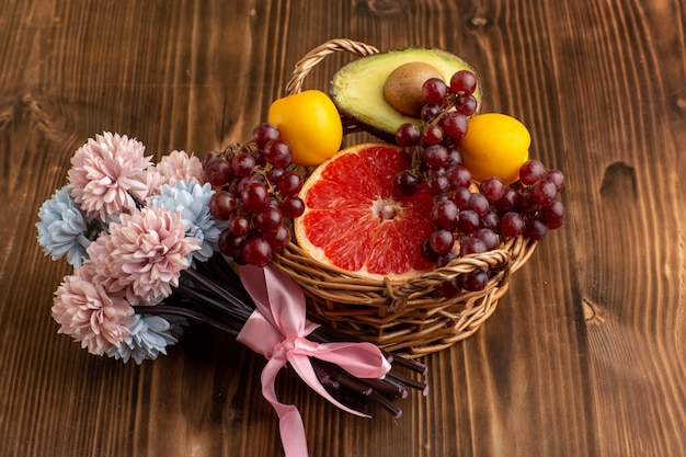 Foto gratuita vista frontal de pomelo fresco con flores sobre superficie de madera