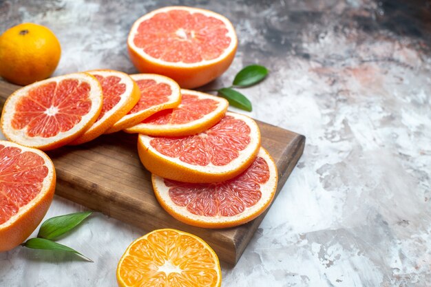 Foto gratuita vista frontal de pomelos frescos en rodajas de frutas en mesa de luz