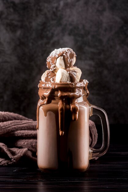 Vista frontal de postre de chocolate en frasco con malvaviscos