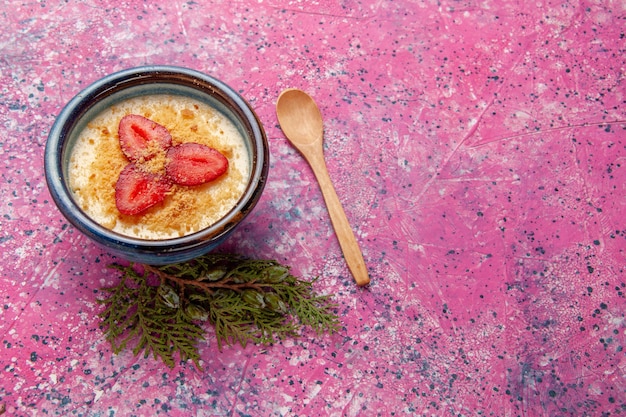 Vista frontal de postre cremoso con fresas rojas sobre la superficie rosada postre helado de frutas de color delicioso baya