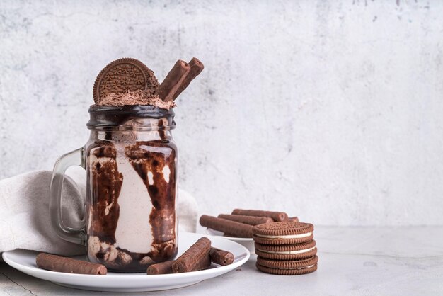 Vista frontal del postre en frasco con galletas de chocolate y espacio de copia