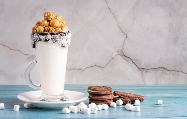 Vista frontal del postre en frasco con palomitas de maíz y galletas