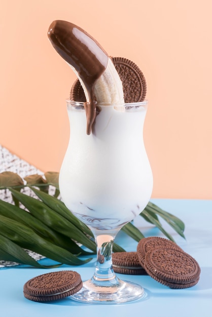 Vista frontal del postre en vaso con chocolate de plátano y galletas