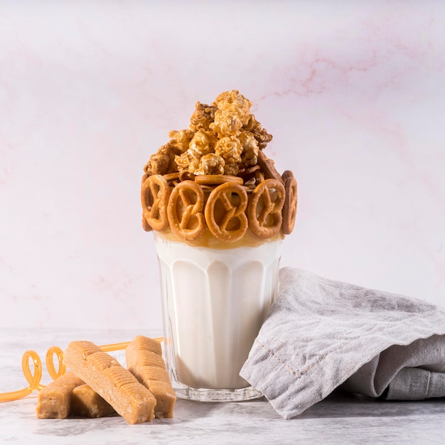 Vista frontal del postre en vaso con pretzels y tela