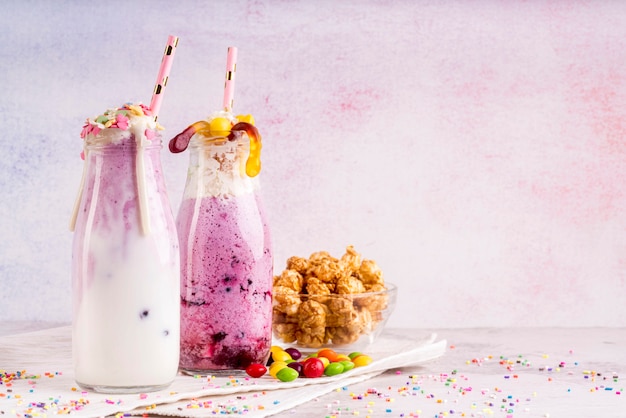 Vista frontal de postres con gusanos de goma y chispas con espacio de copia