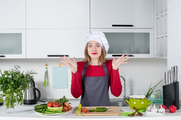 Vista frontal preguntó cocinera en delantal abriendo sus manos