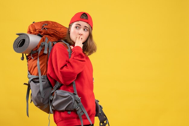 Vista frontal se preguntó mujer viajera con mochila mirando algo