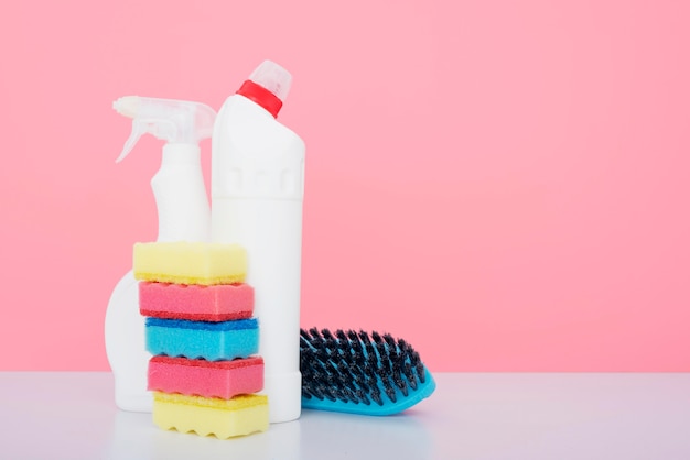 Vista frontal de productos de limpieza con esponjas y cepillo.