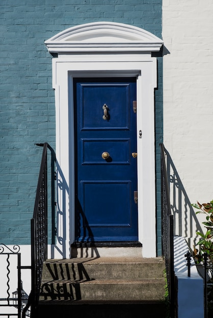 Vista frontal de la puerta principal con pared azul y blanca.