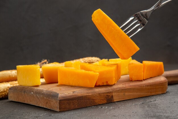 Vista frontal de queso fresco en rodajas con bollos sobre la comida oscura foto en color desayuno crujiente