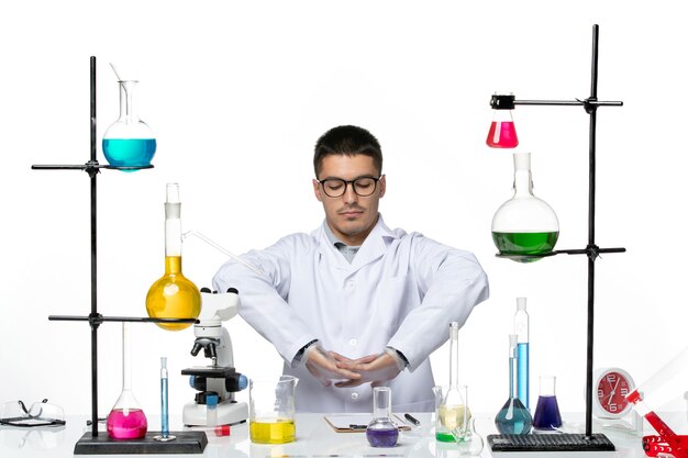 Vista frontal químico masculino en traje médico blanco preparándose para trabajar sobre fondo blanco laboratorio de ciencias de enfermedades virales covid