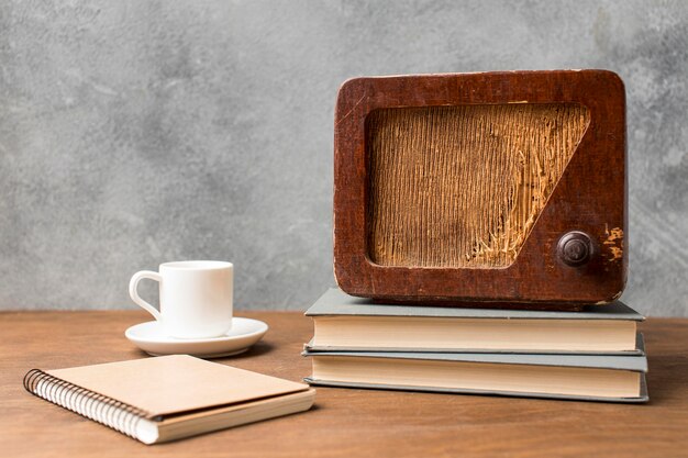 Vista frontal de la radio vintage en la pila de libros y café