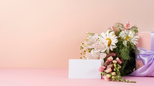 Vista frontal del ramo de flores hermosas con tarjeta en blanco