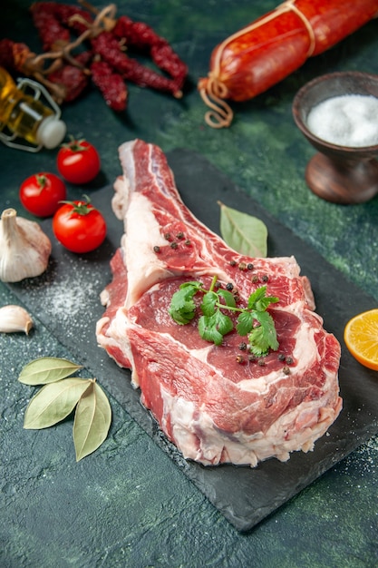Vista frontal de la rebanada de carne fresca con tomates y salchichas en azul oscuro cocina animal vaca color carne carnicero pollo