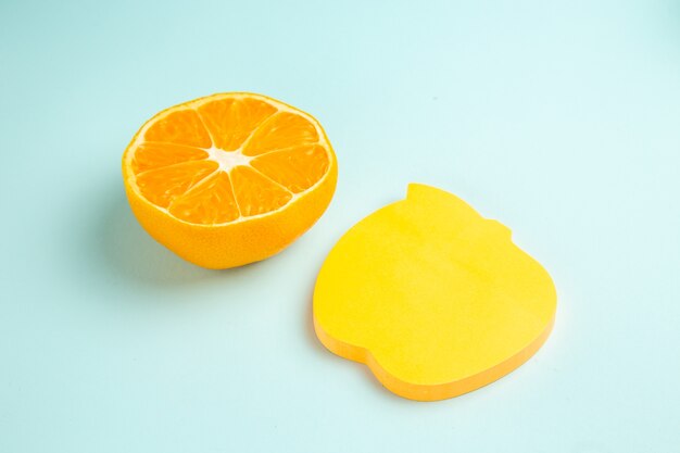 Vista frontal rebanada de mandarina fresca con pegatina en la mesa azul claro