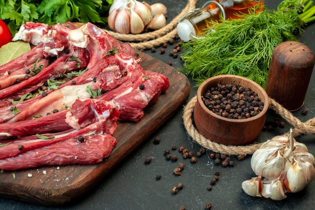 Vista frontal rebanadas de carne cruda con verduras sobre fondo oscuro freír carnicero comida plato comida ensalada carne cocinar