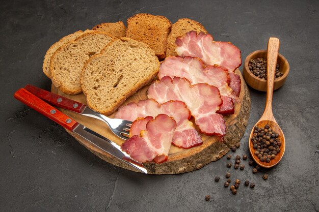 Vista frontal de las rebanadas de jamón fresco con bollos y rebanadas de pan en un bocadillo oscuro color carne comida comida