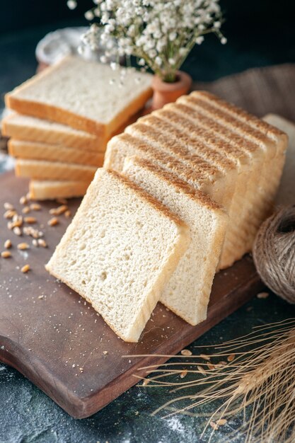 Vista frontal de rebanadas de pan blanco sobre fondo oscuro bollo masa panadería té comida hogaza mañana pastelería