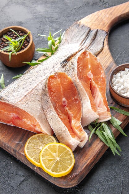 Vista frontal rebanadas de pescado fresco con limón sobre fondo oscuro comida color agua carne comida océano cena mariscos salud