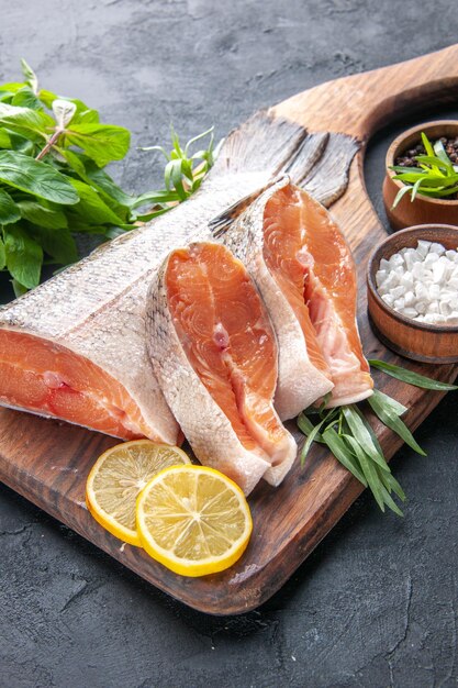 Vista frontal rebanadas de pescado fresco con limón sobre fondo oscuro comida color agua comida océano cena salud carne