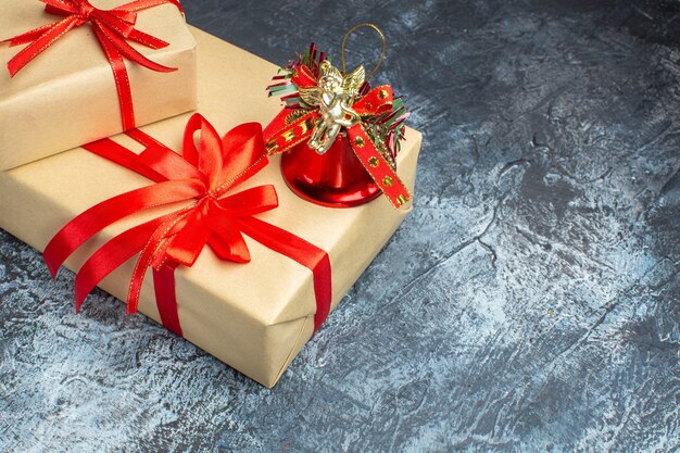 Vista frontal de regalos de navidad atados con lazos rojos en color claro-oscuro regalo de navidad de año nuevo foto de vacaciones