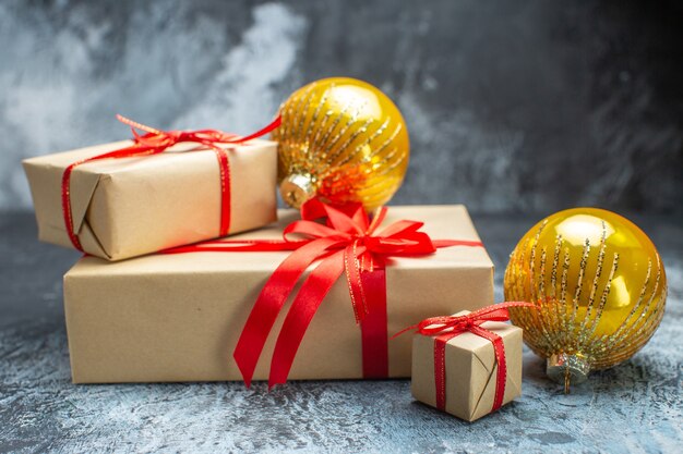 Vista frontal de regalos de navidad atados con lazos rojos y juguetes en la foto de año nuevo claro-oscuro regalo de navidad en color