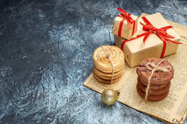 Vista frontal de regalos de navidad con galletas y juguetes en un regalo claro-oscuro foto en color año nuevo vacaciones de navidad espacio libre