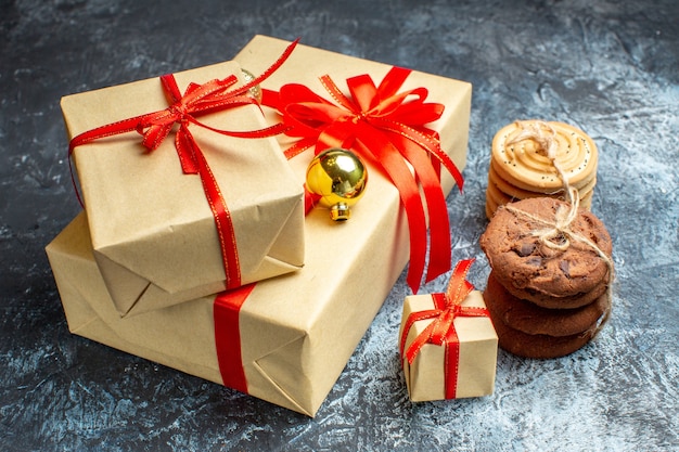 Vista frontal de regalos de navidad con galletas en luz-oscuridad regalo fotográfico navideño color de navidad año nuevo