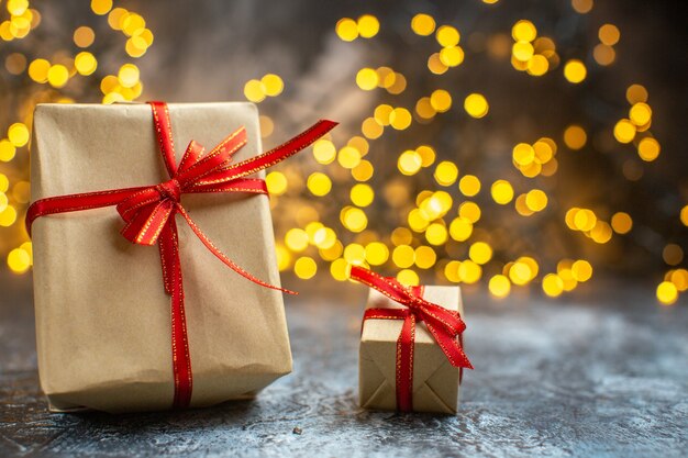 Vista frontal de regalos navideños con luces amarillas en color de año nuevo navideño claro-oscuro