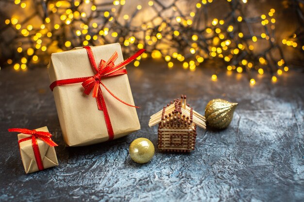 Vista frontal de regalos navideños con luces amarillas en color de año nuevo navideño claro-oscuro