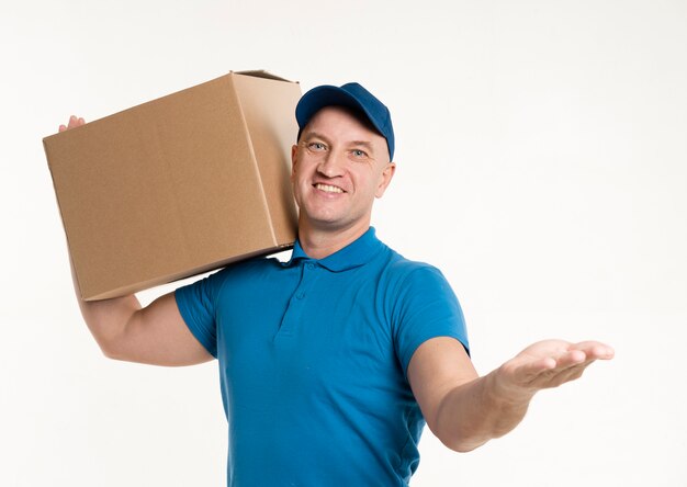 Vista frontal del repartidor llevando una caja de cartón