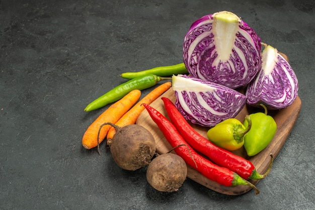 Vista frontal de repollo morado fresco con otras verduras en el escritorio oscuro dieta ensalada madura salud