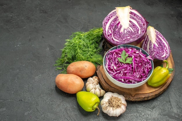 Vista frontal de repollo morado fresco con verduras y verduras en la mesa oscura ensalada dieta salud madura