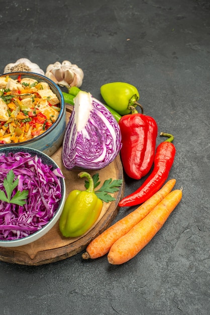 Vista frontal de repollo rojo con verduras frescas en una ensalada de dieta madura de salud de mesa gris oscuro