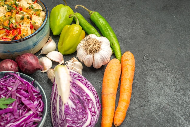 Vista frontal de repollo rojo con verduras frescas en mesa gris oscuro dieta salud ensalada madura