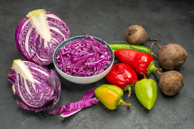 Vista frontal de repollo rojo con verduras frescas en la mesa oscura dieta saludable ensalada madura