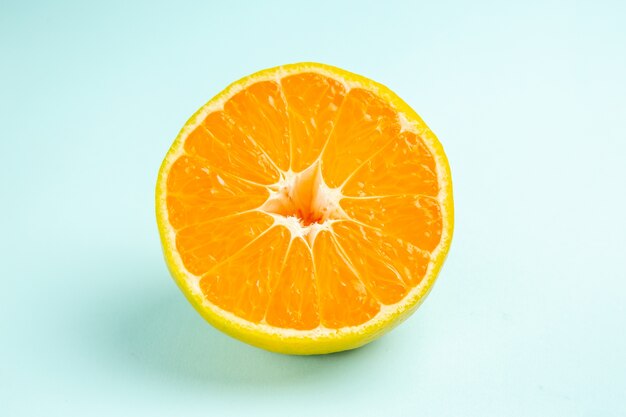 Vista frontal rodaja de mandarina fresca sobre la mesa azul claro