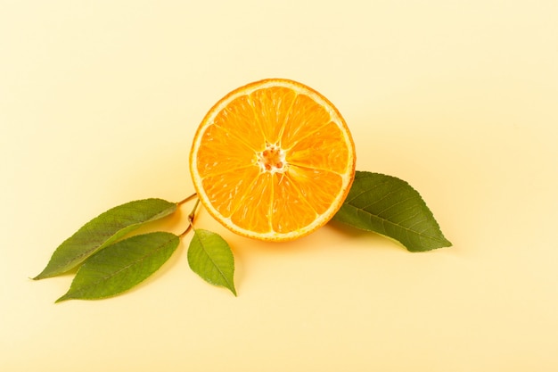 Una vista frontal rodaja de naranja fresca dulce jugosa madura aislado junto con hojas verdes en el fondo de color crema jugo de cítricos verano
