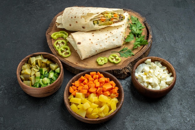 Vista frontal en rodajas delicioso sándwich de ensalada shaurma en superficie gris sándwich de hamburguesa de ensalada de comida de pita