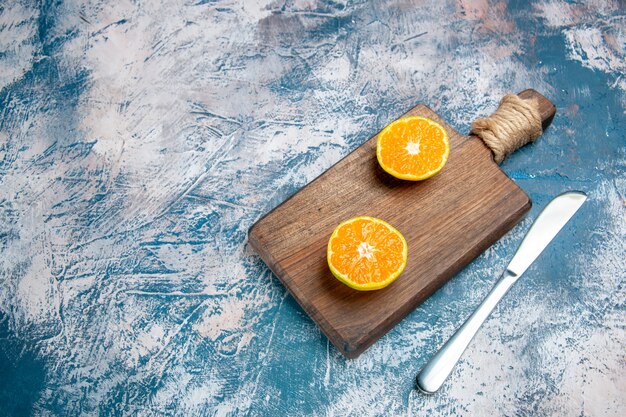 Vista frontal de rodajas de mandarina fresca sobre la mesa azul claro