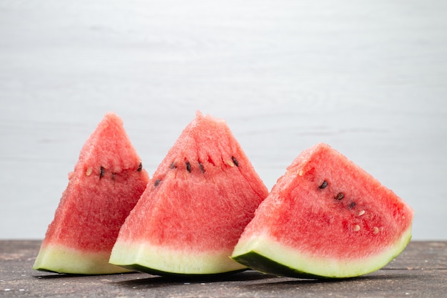 Vista frontal rodajas de sandía frutas frescas jugosas y suaves en gris, jugo de fruta de verano