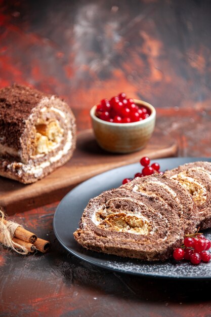 Vista frontal de rollos de galletas con frutos rojos sobre superficie oscura