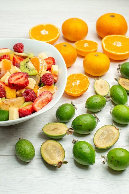 Vista frontal sabrosa ensalada de frutas con feijoas frescas y mandarinas en baya blanca foto árbol frutal suave