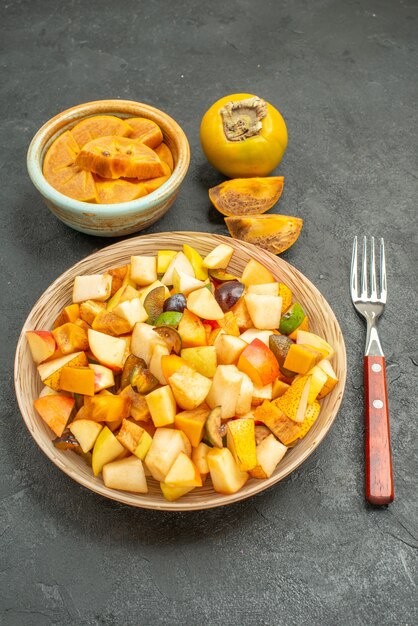 Vista frontal sabrosa ensalada de frutas con frutas frescas en la mesa oscura muchas frutas frescas