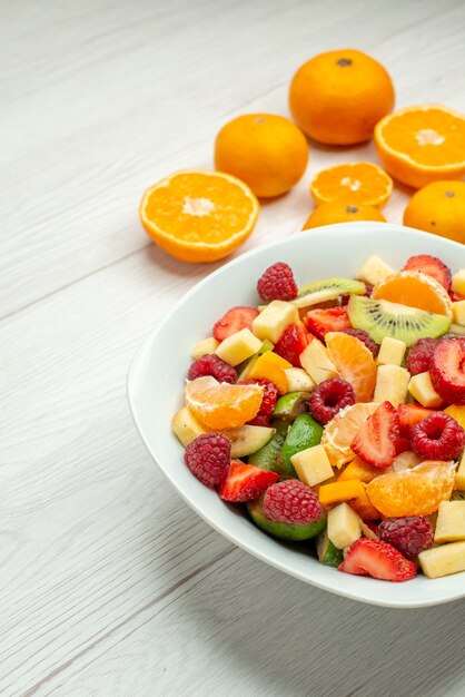 Vista frontal sabrosa ensalada de frutas con mandarinas frescas en blanco baya suave foto árbol frutal salud madura