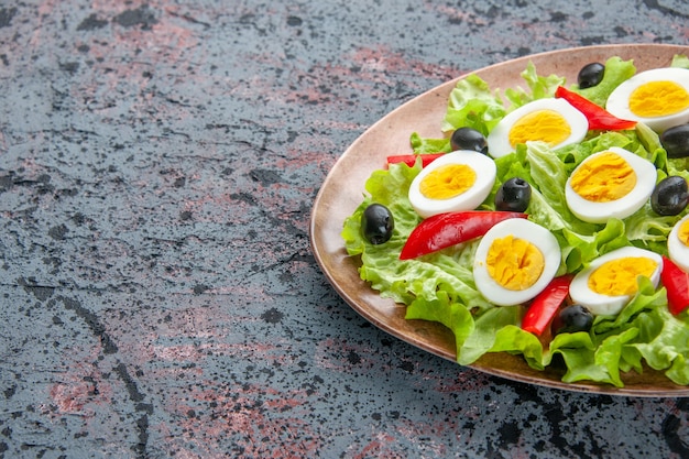 Vista frontal sabrosa ensalada de huevo con ensalada verde y aceitunas sobre fondo claro